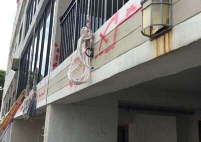 A building facade with rope maintenance equipment and a person working.