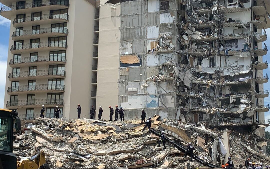 Collapsed building with rescuers, debris, and REMEMBERING Surfside text overlay.